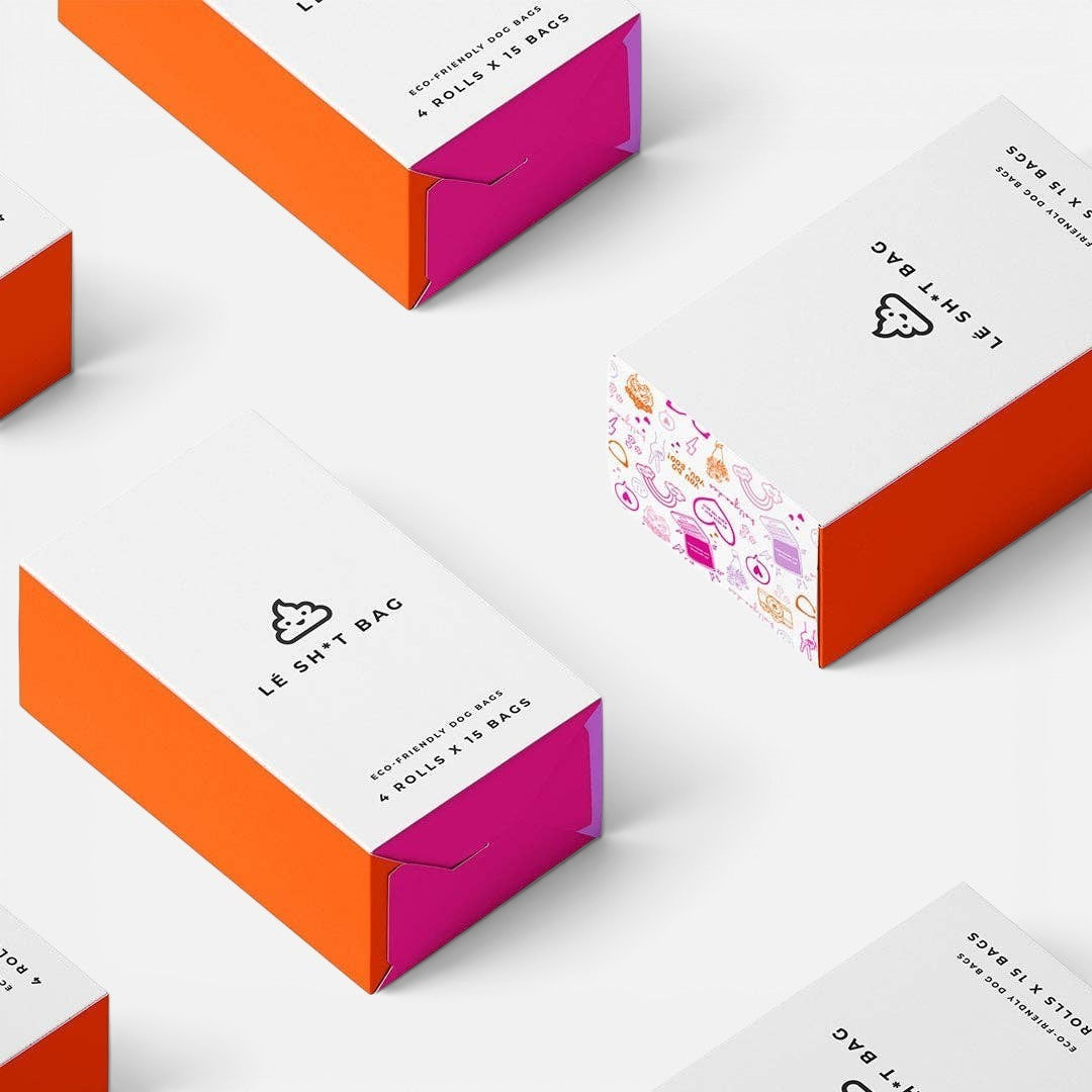 The Dog Emporium Lé Sh*t Bag compostable dog waste bag boxes in white and orange packaging with playful illustrations.