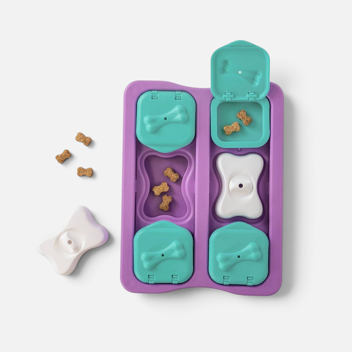 The Dog Emporium Outward Hound Nina Ottosson Dog Brick interactive puzzle toy with purple, teal, and white compartments.