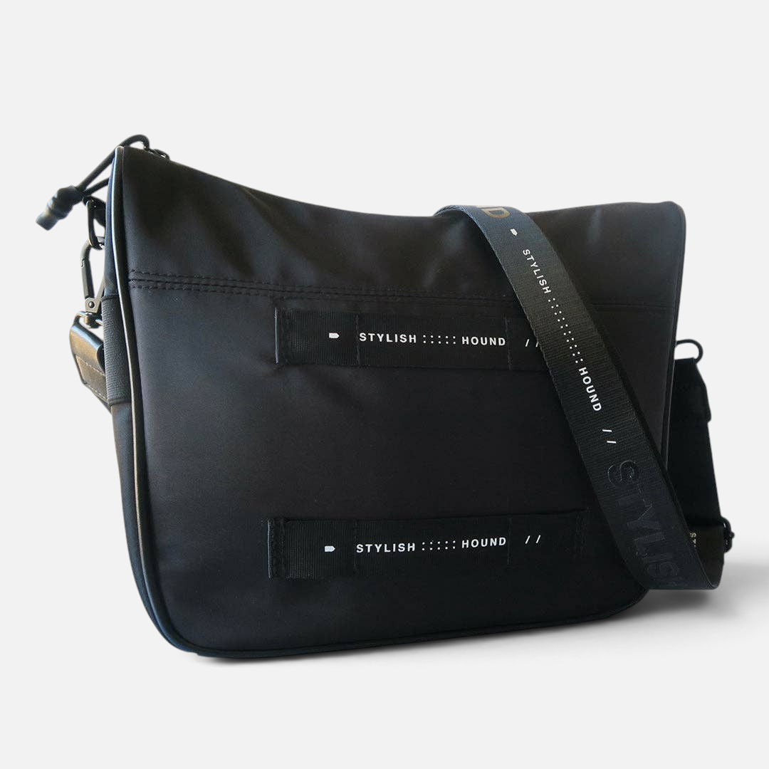 The Dog Emporium Day Tripper bag in black canvas with adjustable branded strap and front storage loops