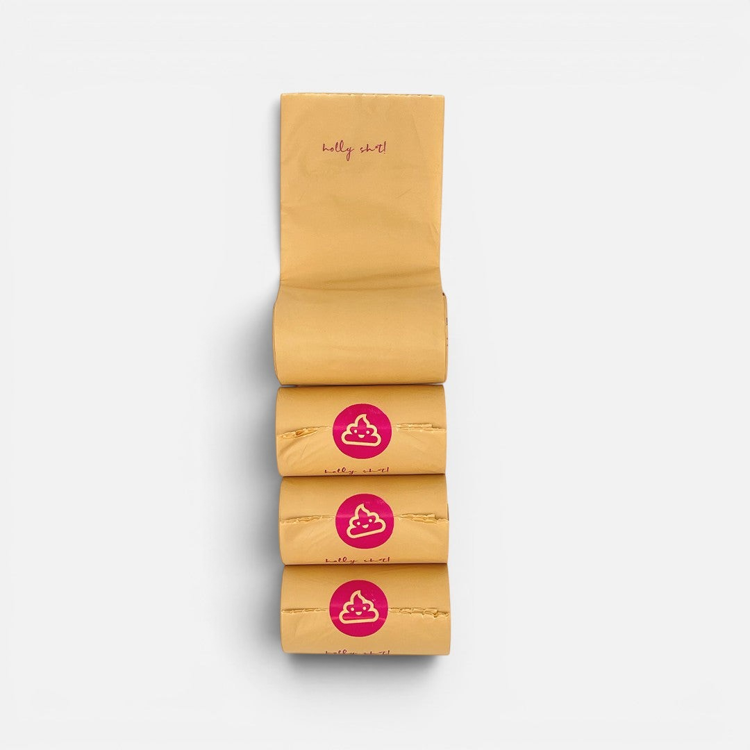 The Dog Emporium compostable dog poop bag rolls in tan corn starch material with pink poop emoji stickers