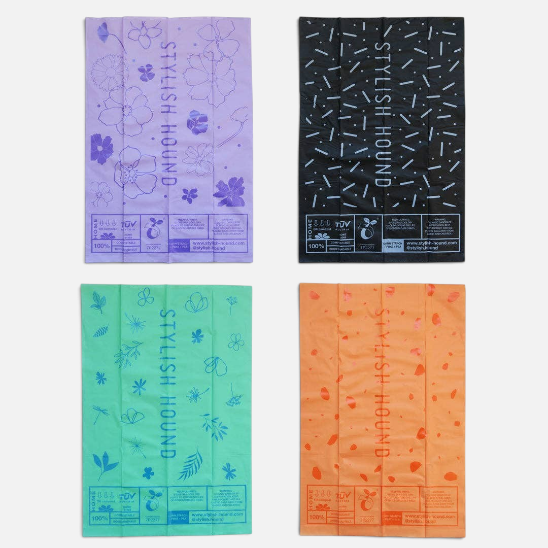 The Dog Emporium biodegradable poop bags in lilac, black, aqua, and orange with floral and geometric patterns.