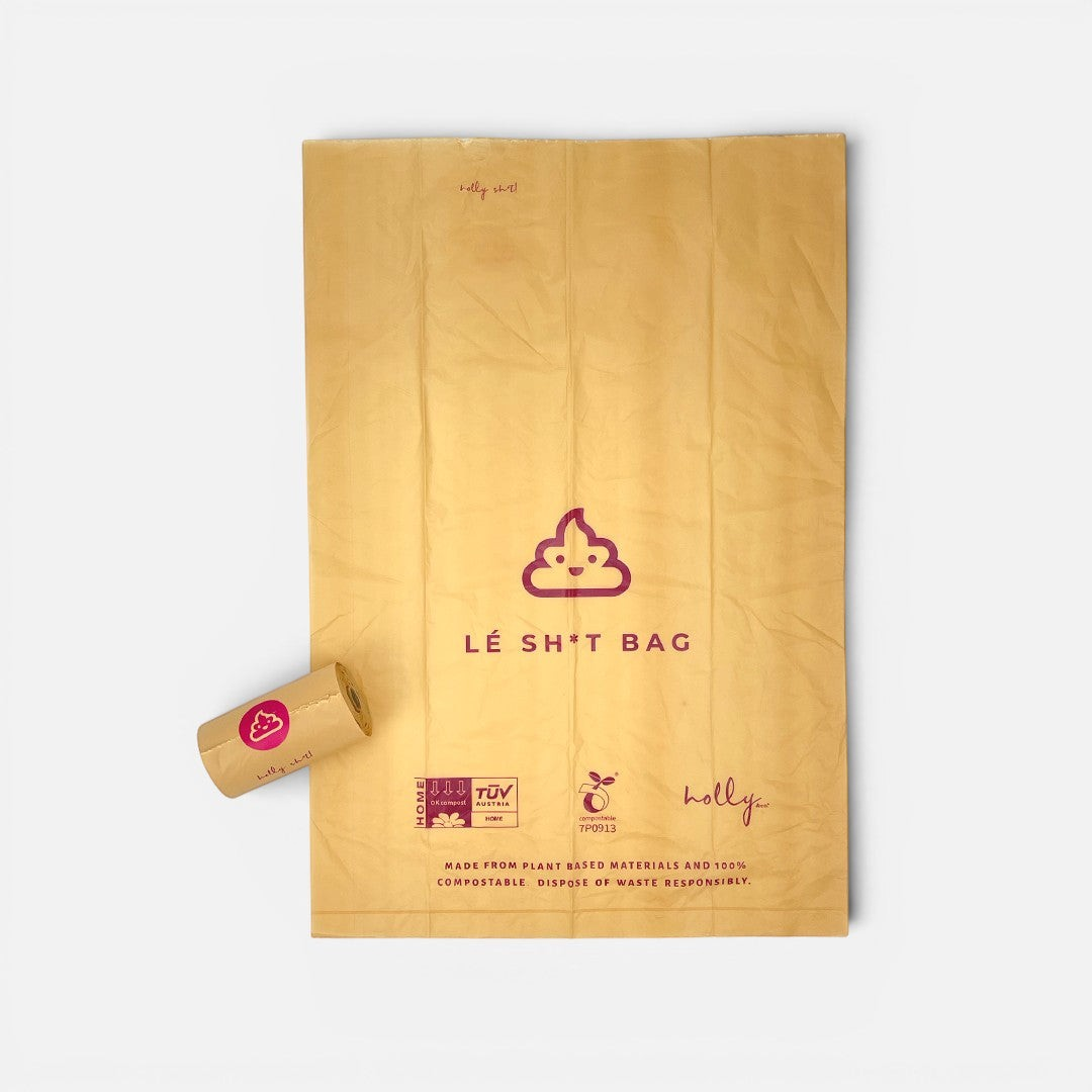 The Dog Emporium compostable dog waste bag and roll in tan with a purple poop emoji logo and branding