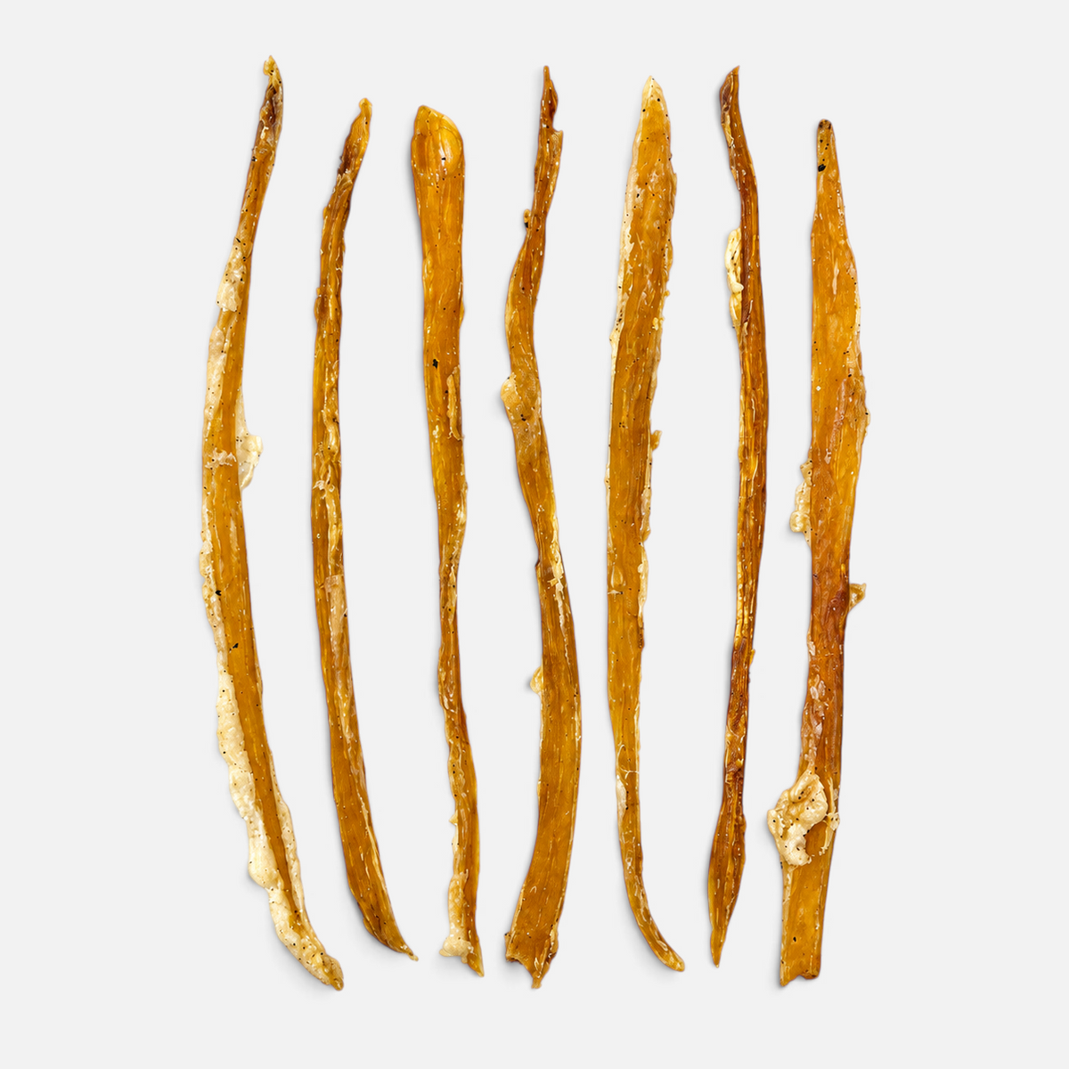 Seven natural brown collagen sticks for dogs from The Dog Emporium arranged vertically on a light grey background.
